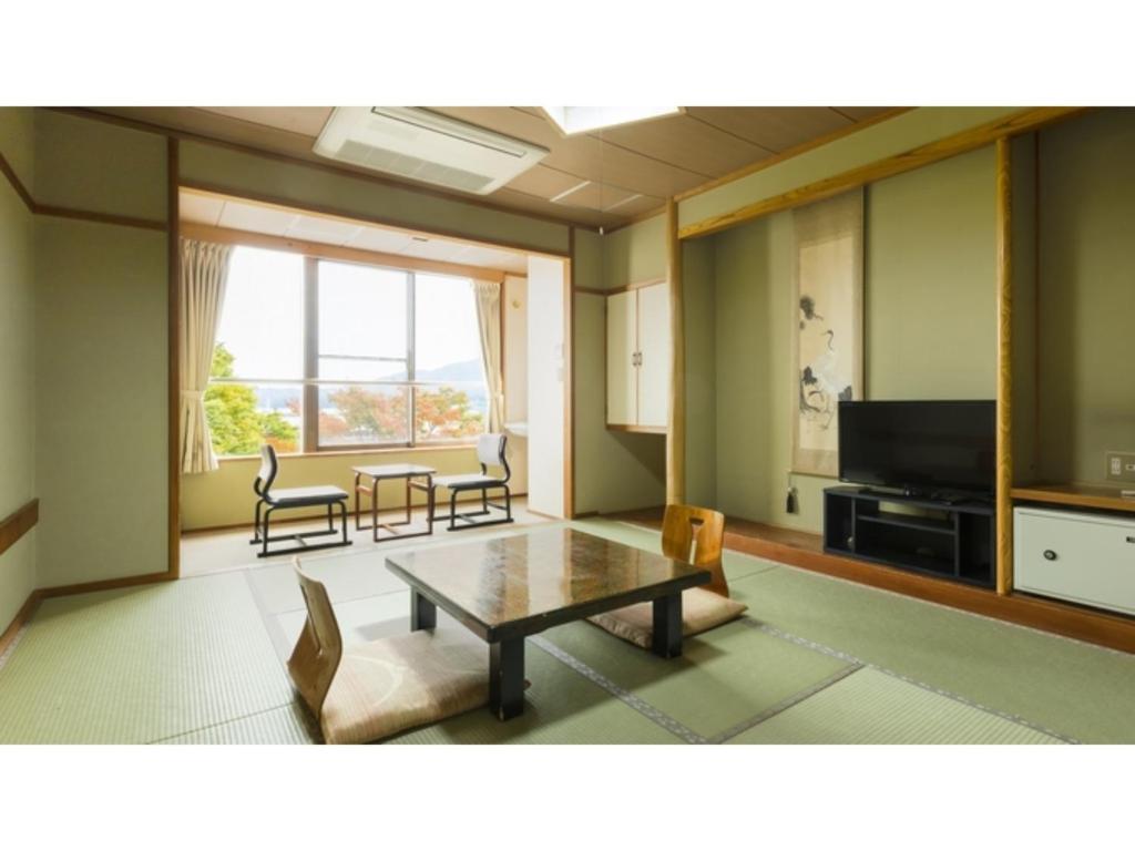 - un salon avec une table et une télévision dans l'établissement Hotel Omiya - Vacation STAY 81533v, à Miyako