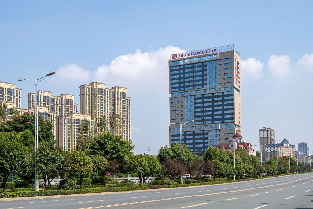 un'autostrada con un palazzo alto in città di Hilton Garden Inn Changde Dingcheng a Changde