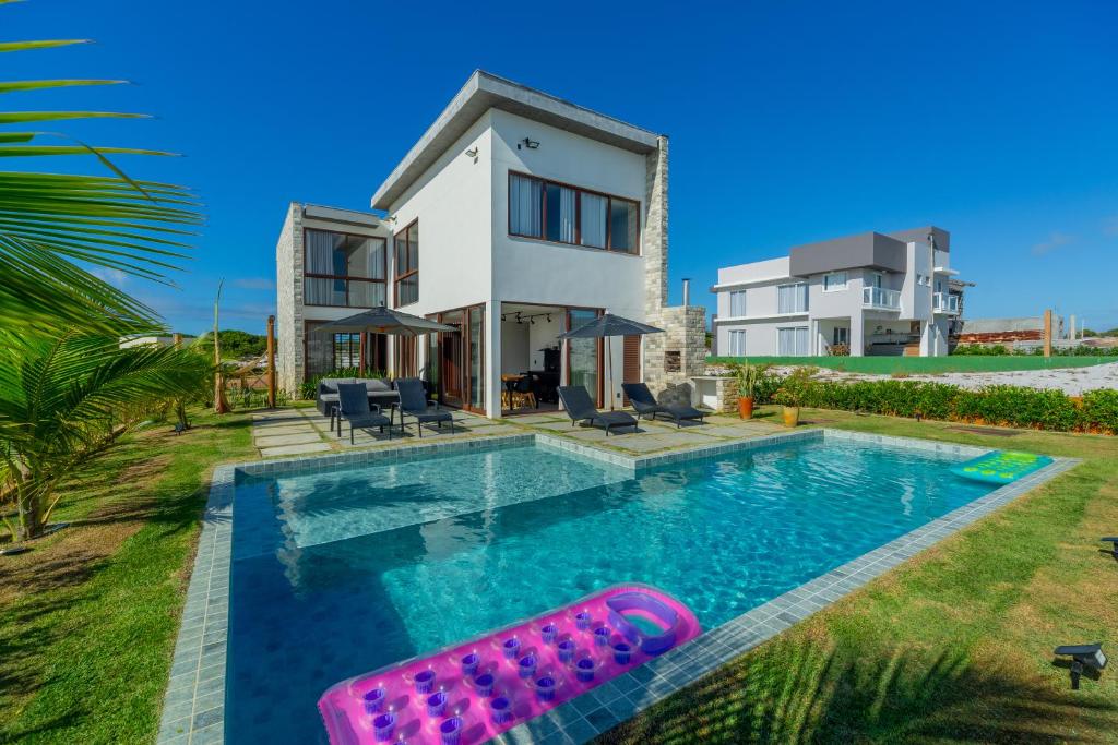 een villa met een zwembad en een huis bij Reserva Sauípe - Casa 224 in Mata de Sao Joao