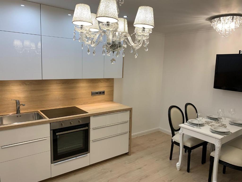 a kitchen with a sink and a table with chairs at Apartment Naturjuwel in Hünxe