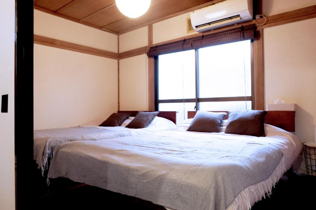 two beds in a room with a large window at Daiichi Mitsumi Corporation - Vacation STAY 14914 in Musashino