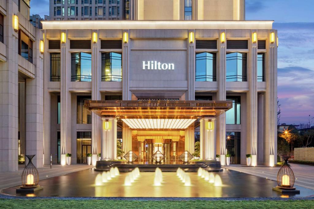 un hotel con una entrada iluminada a un edificio en Hilton Chengdu Chenghua, en Chengdú