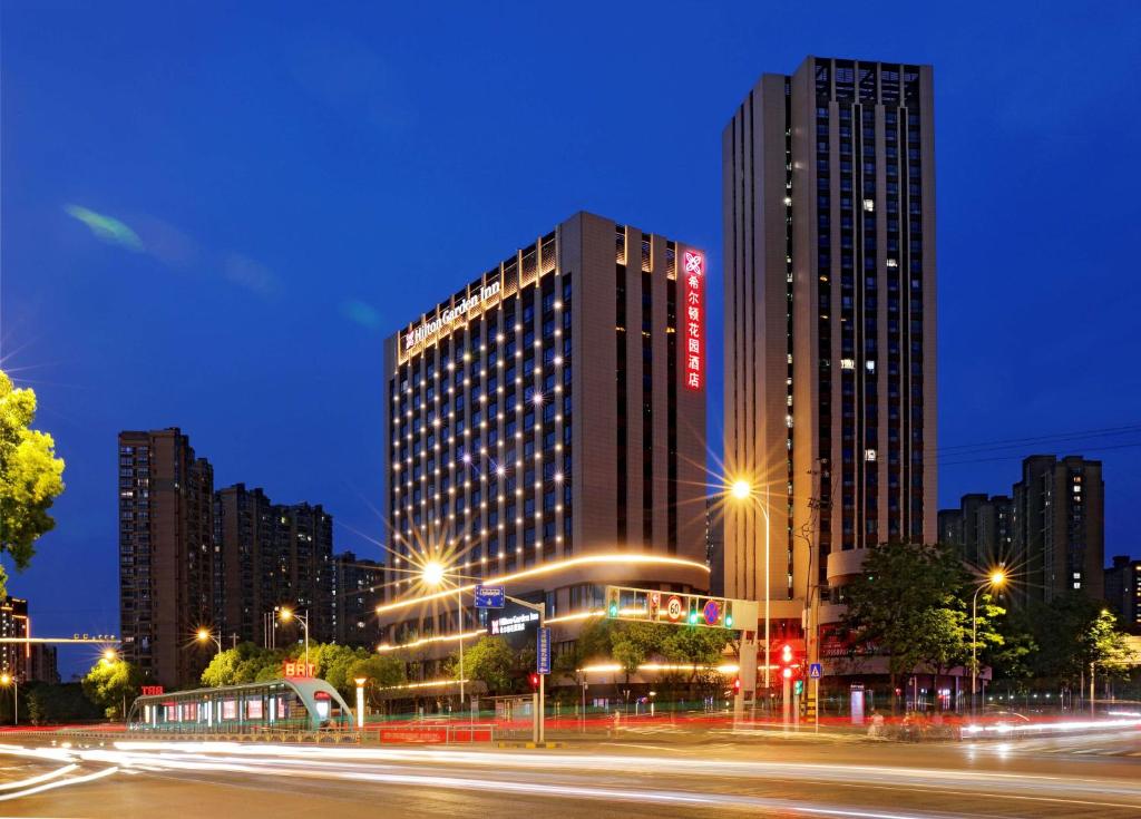 una città di notte con edifici e lampioni di Hilton Garden Inn Changzhou Xinbei a Changzhou