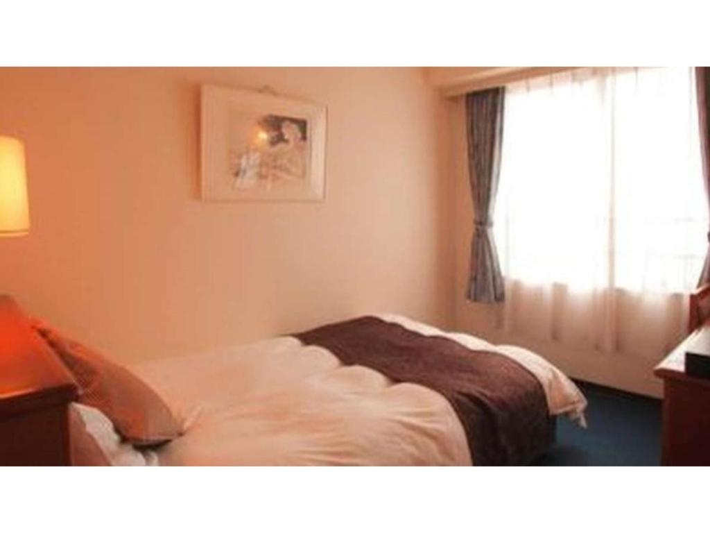 1 dormitorio con cama y ventana en Hotel Sekumiya - Vacation STAY 21687v, en Obama