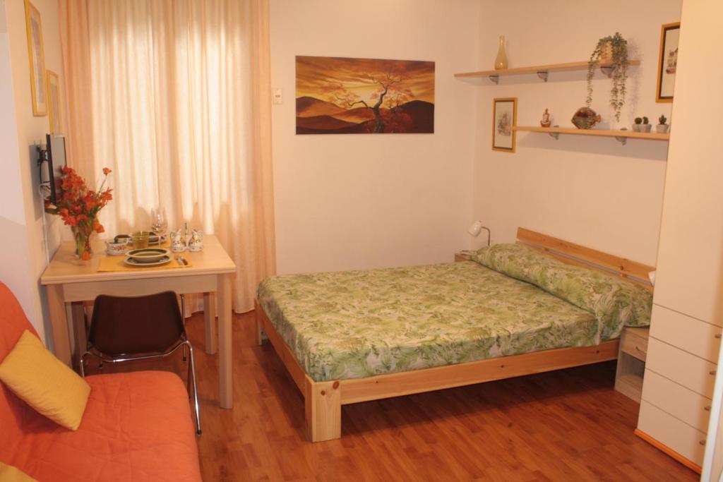 una camera con letto, tavolo e scrivania di Nice Apartment in Taormina a Taormina