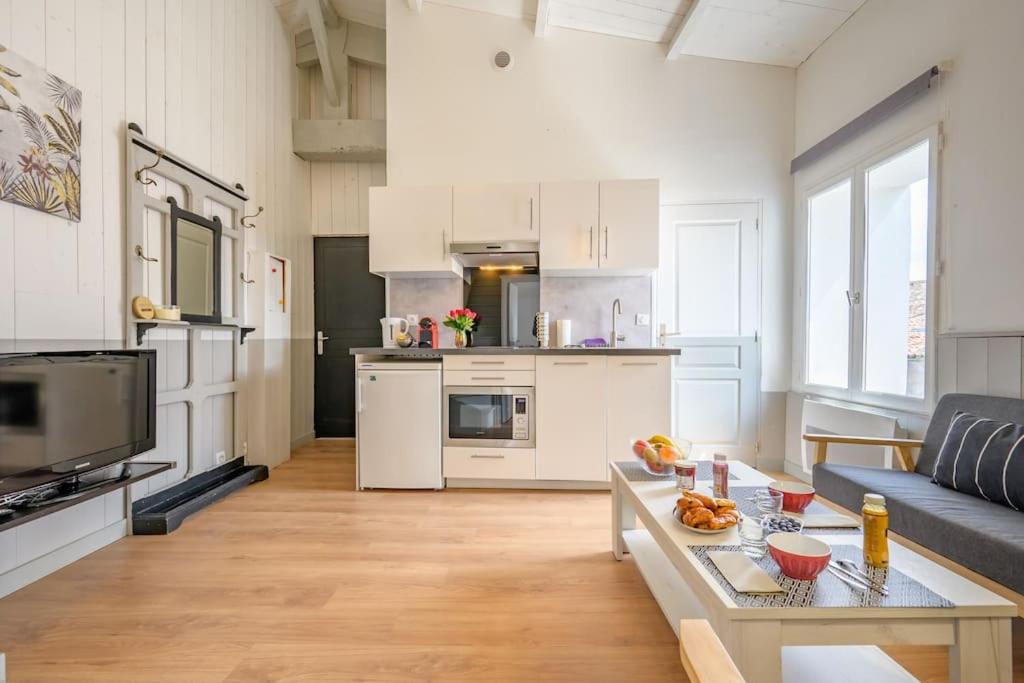 un grand salon avec un canapé et une table dans l'établissement Au cœur de St Martin : Le Grouin, à Saint-Martin-de-Ré