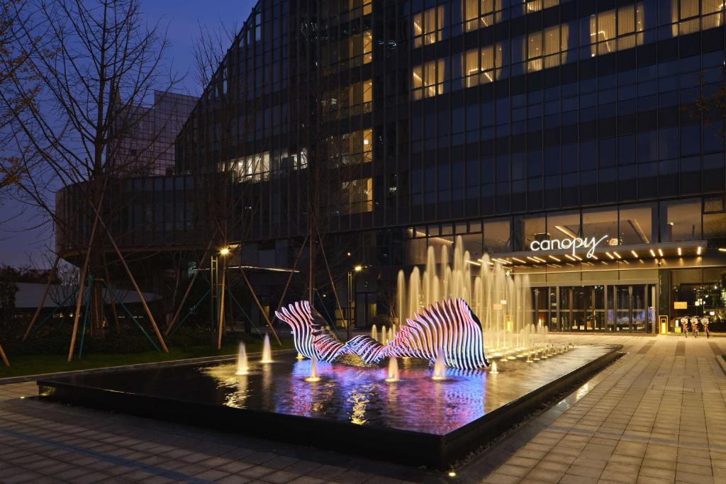 a fountain with three zebras in front of a building at Canopy By Hilton Hangzhou Jinsha Lake in Hangzhou