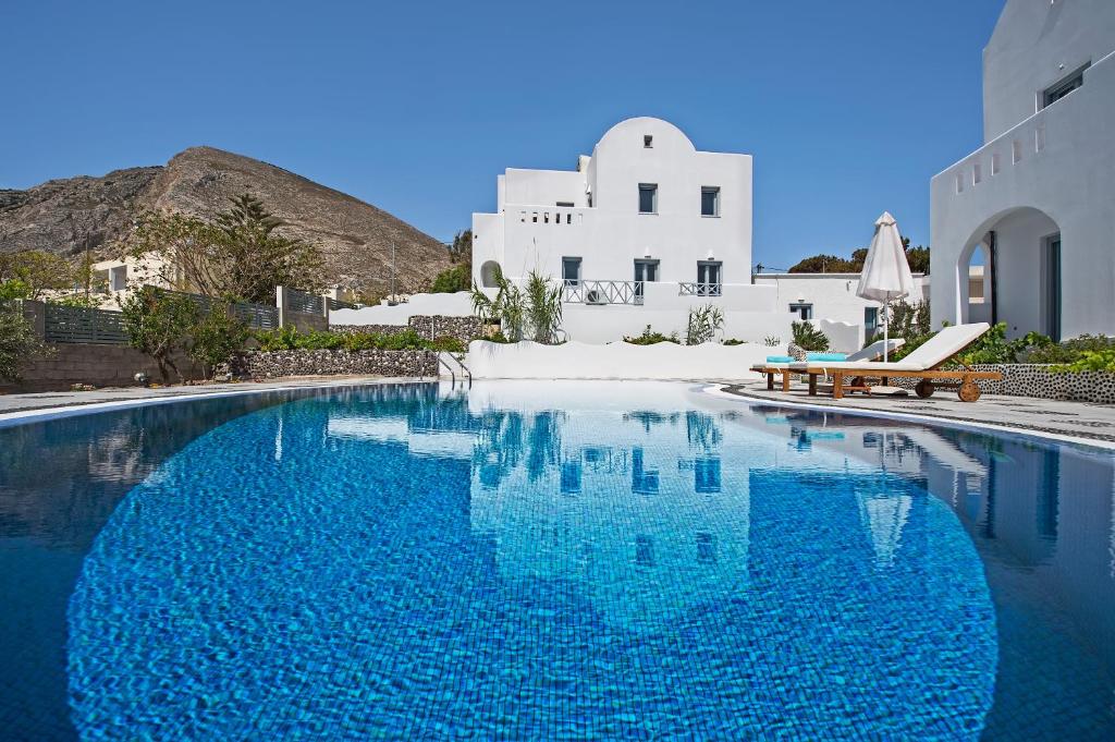 a swimming pool in front of a white building at Felicity Luxury Villas in Kamari