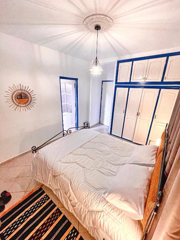 a large bed in a room with a large window at Dar Bakkali Nadi in Tangier