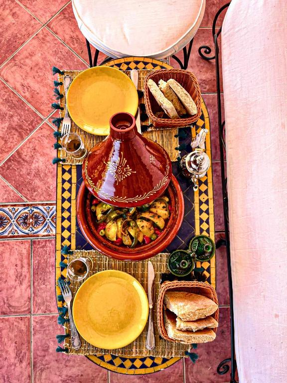 a table with plates of food and a tea pot at Dar Bakkali Nadi in Tangier