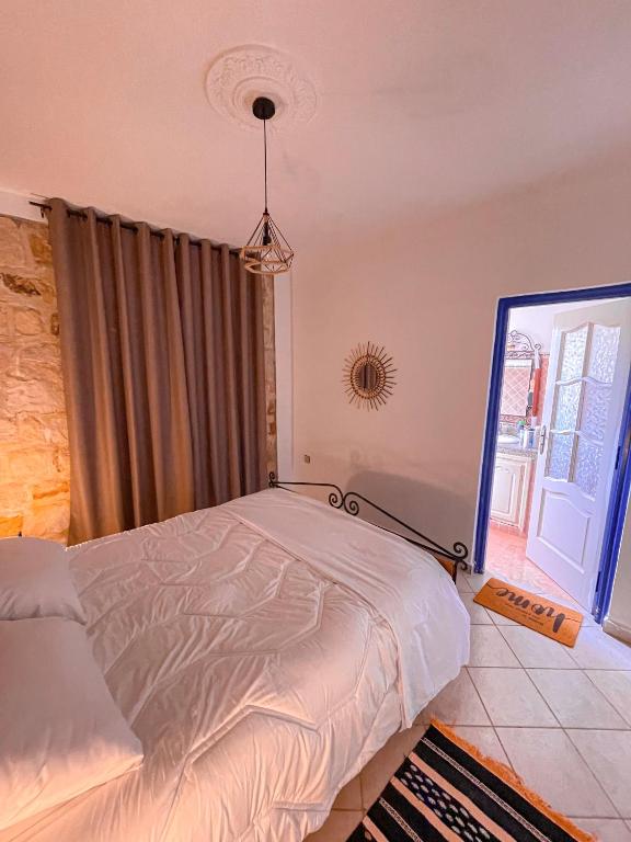 a bedroom with a bed and a large window at Dar Bakkali Nadi in Tangier