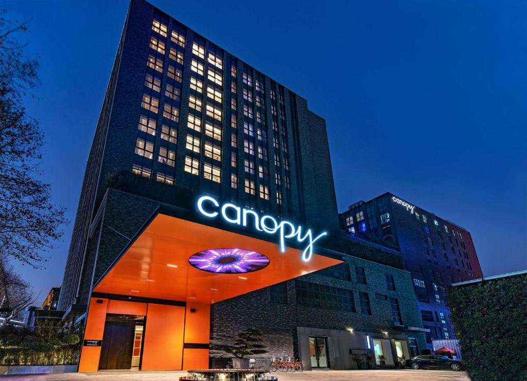 un bâtiment avec un panneau d'accrobranche devant lui dans l'établissement Canopy by Hilton Hangzhou West Lake, à Hangzhou
