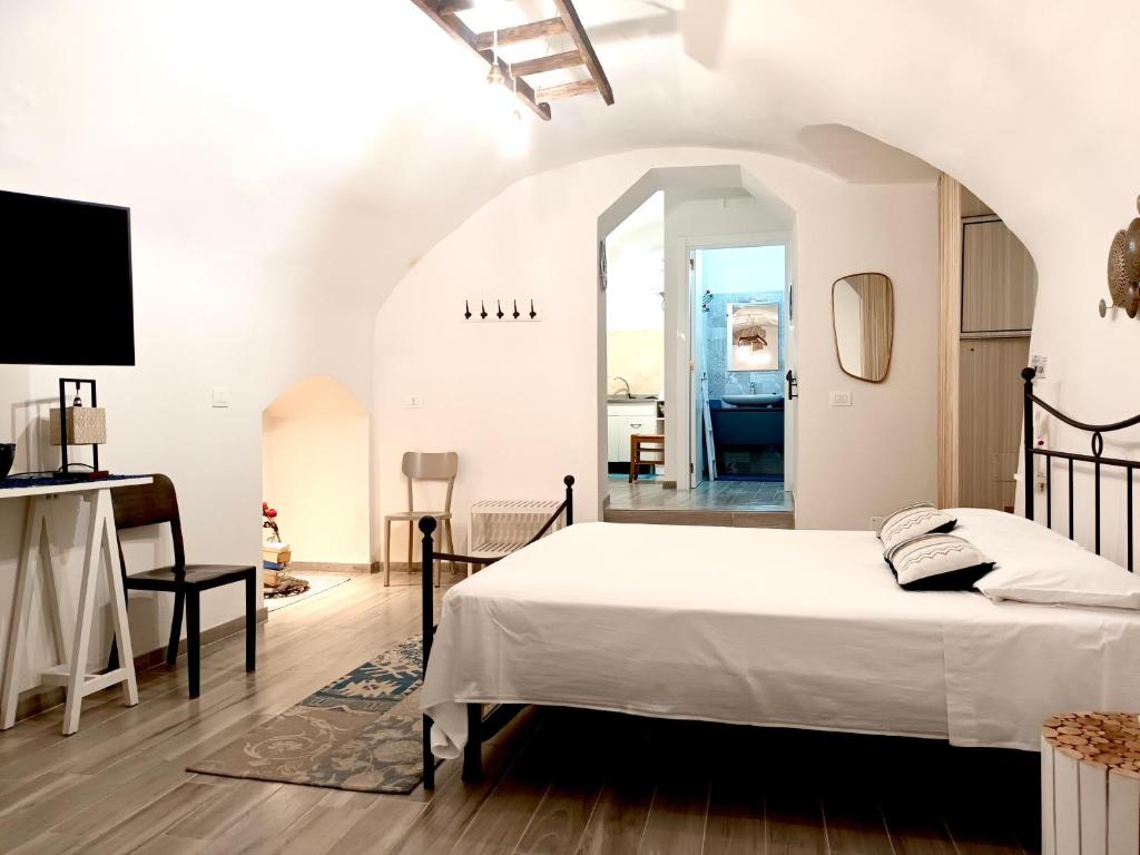 a bedroom with a bed and a living room at Antiche Mura Apartments"Nido di Puglia" monovano in Turi