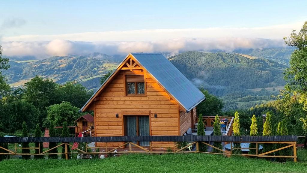 a log cabin with mountains in the background at Domek Góralski Piwowarówka in Piwniczna