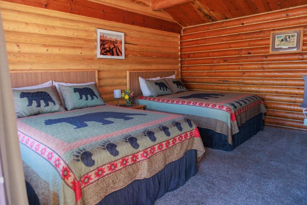 a bedroom with two beds in a log cabin at Creekside Cabins in Saint Ignatius