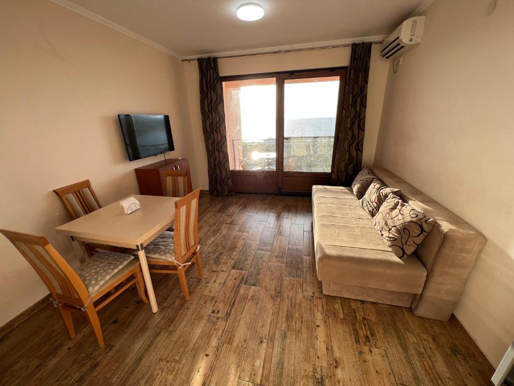 een woonkamer met een bank en een tafel bij Apartment Sea View Dobra Voda in Dobra Voda