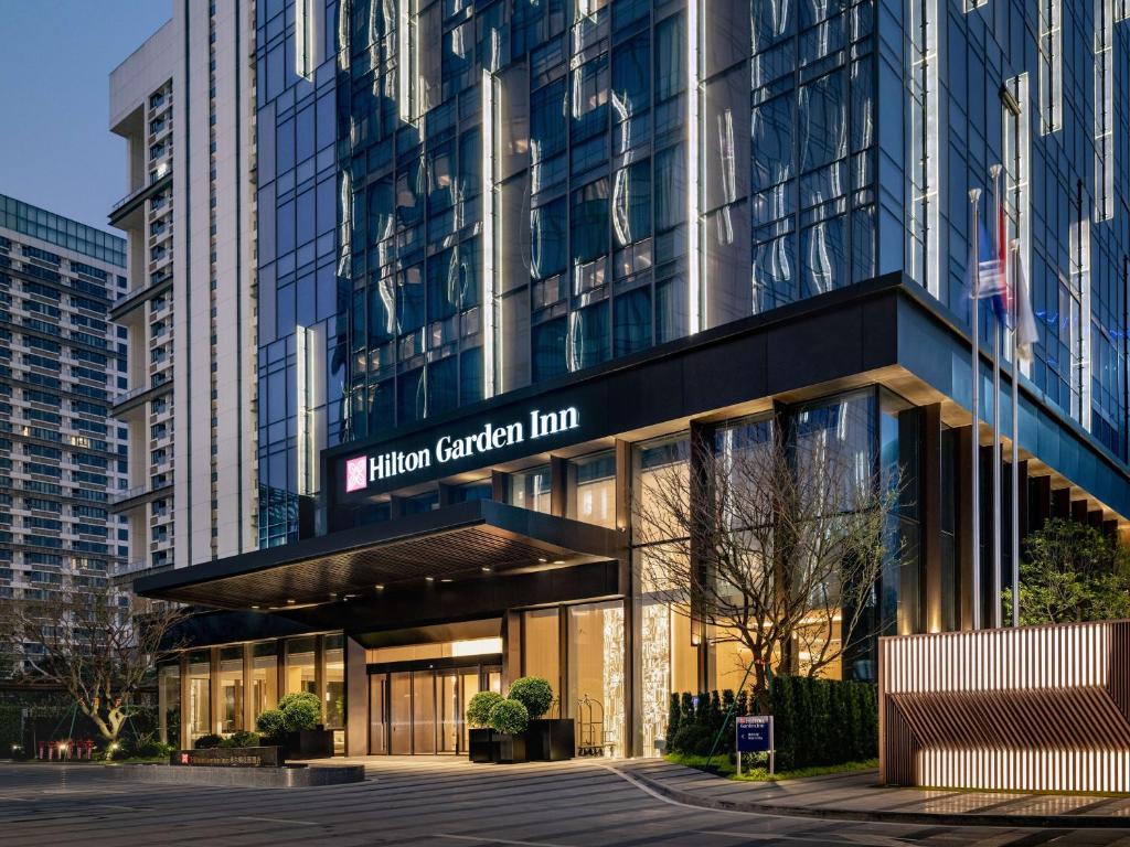a building with a sign for the hilton garden inn at Hilton Garden Inn Shenzhen World Exhibition & Convention Center in Shenzhen