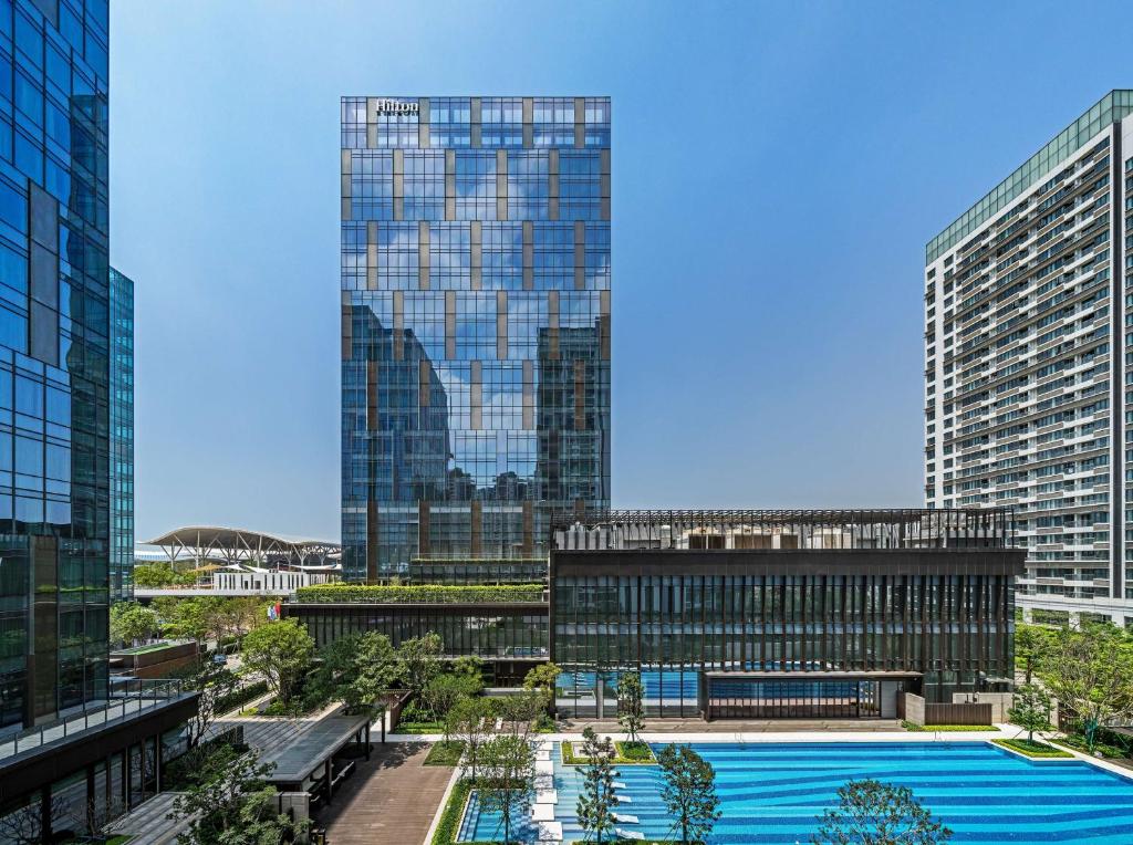 a view of a building with a pool in front of it at Hilton Shenzhen World Exhibition & Convention Center in Shenzhen