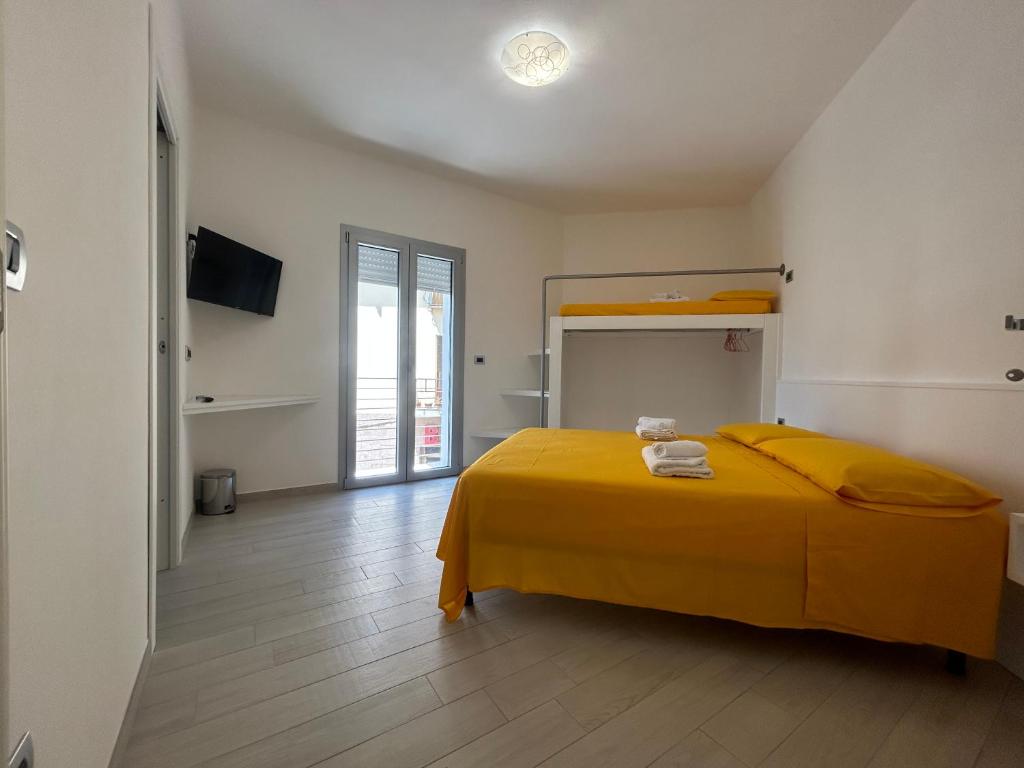 - une chambre avec un lit et une couverture jaune dans l'établissement Domu Dina Affittacamere 1, à Tertenìa