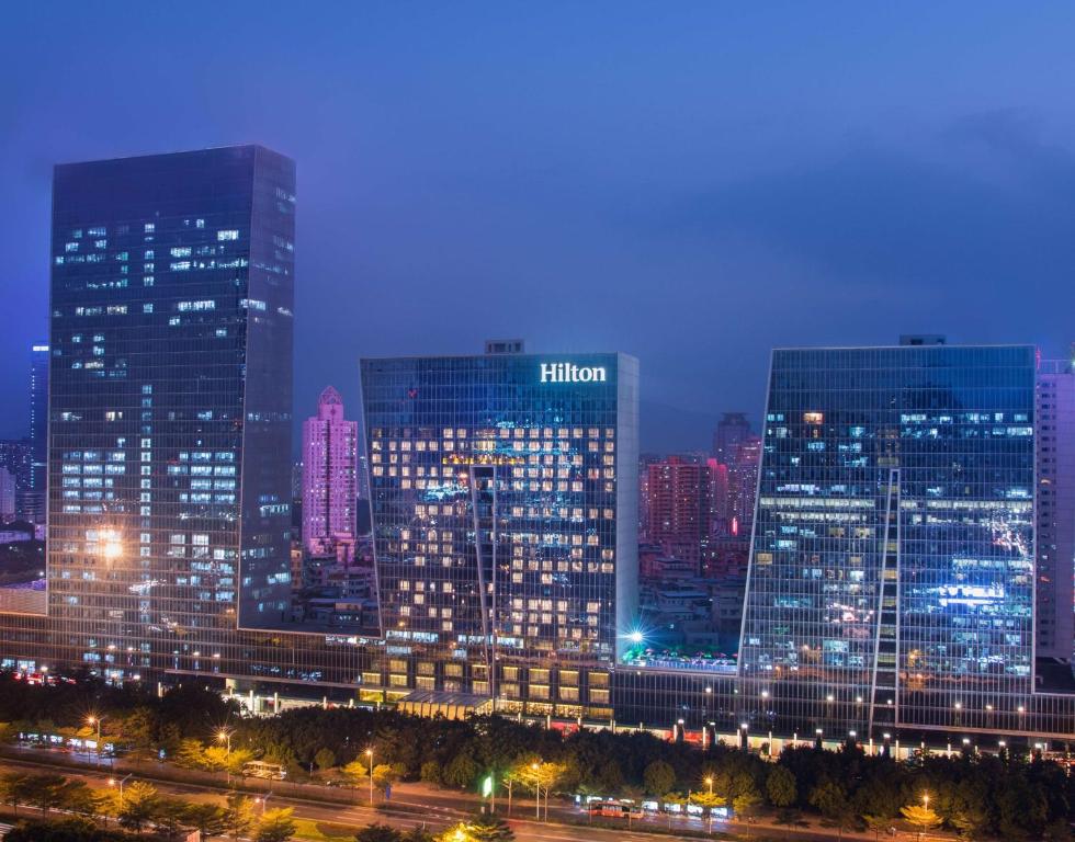 a lit up city skyline at night with tall buildings at Hilton Shenzhen Futian, Metro Station at Hotel Front Door, Close to Futian Convention & Exhibition Center in Shenzhen