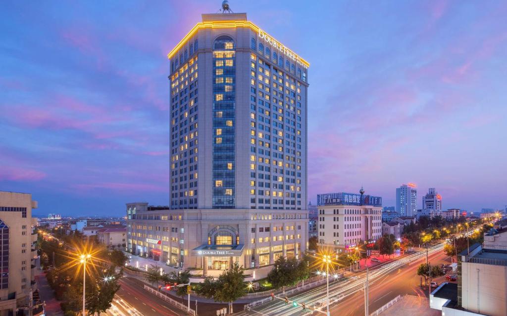 um edifício alto com uma cruz em cima em DoubleTree by Hilton Hotel Qingdao-Jimo Ancient City em Jimo