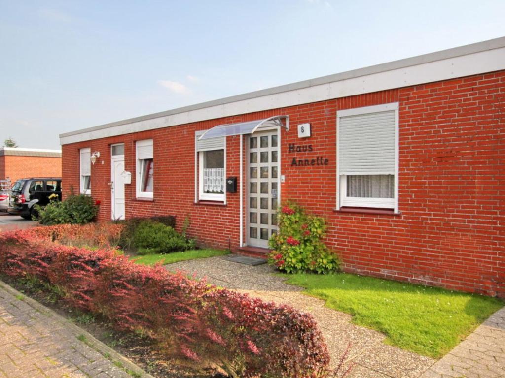 a red brick building with a white door at Bungalow, Dornumersiel in Dornumersiel