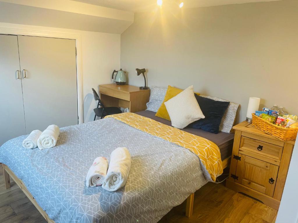 Cosy loft room in Morningside, Edinburgh في إدنبرة: غرفة نوم عليها سرير وفوط
