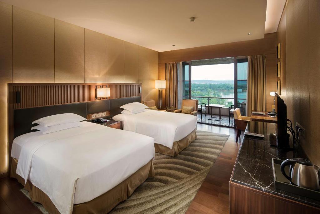 Postel nebo postele na pokoji v ubytování Hilton Wuhan Optics Valley
