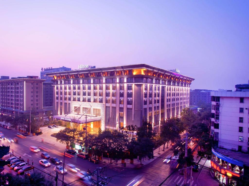 duży budynek z ulicą przed nim w obiekcie Hilton Xi'an w mieście Xi'an