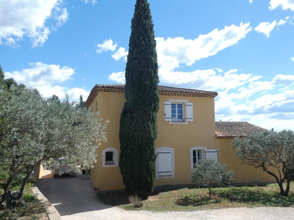 a large tree in front of a yellow house at Maison Morin in Aups