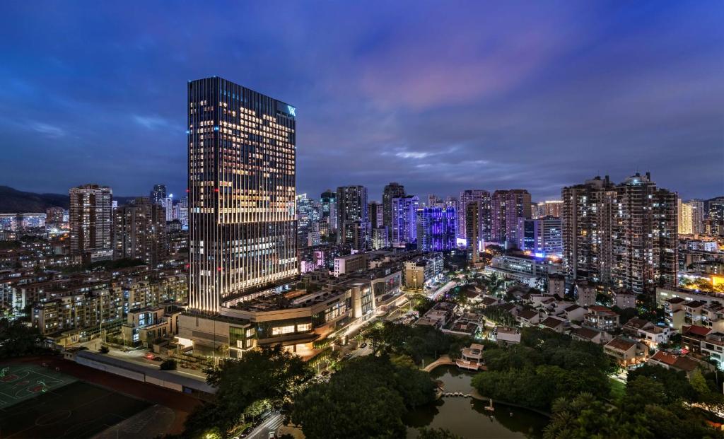 eine Skyline der Stadt in der Nacht mit einem hohen Gebäude in der Unterkunft Waldorf Astoria Xiamen in Xiamen
