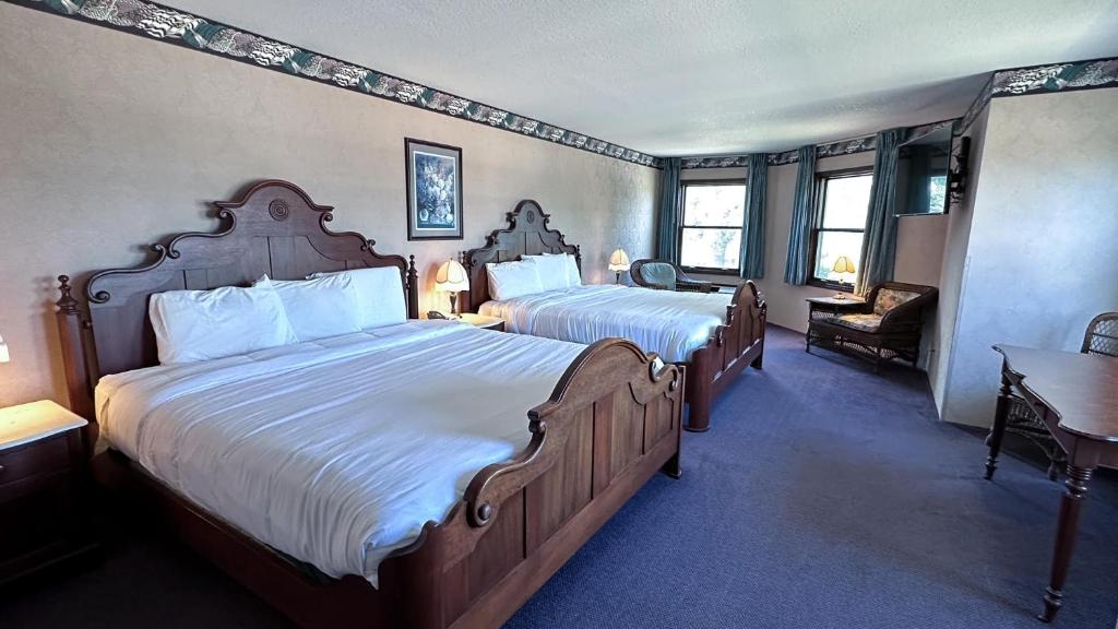 um quarto de hotel com duas camas e uma mesa e cadeiras em The Shelby Inn em Shelbyville