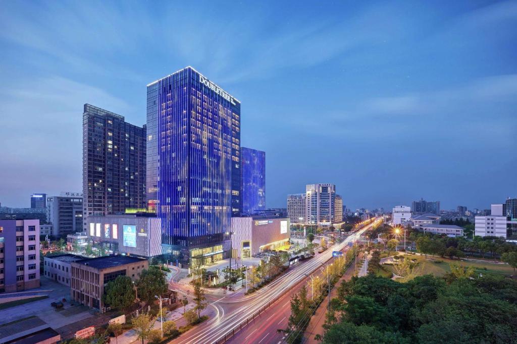 um horizonte da cidade com edifícios altos e uma auto-estrada em Doubletree By Hilton Yangzhou em Yangzhou