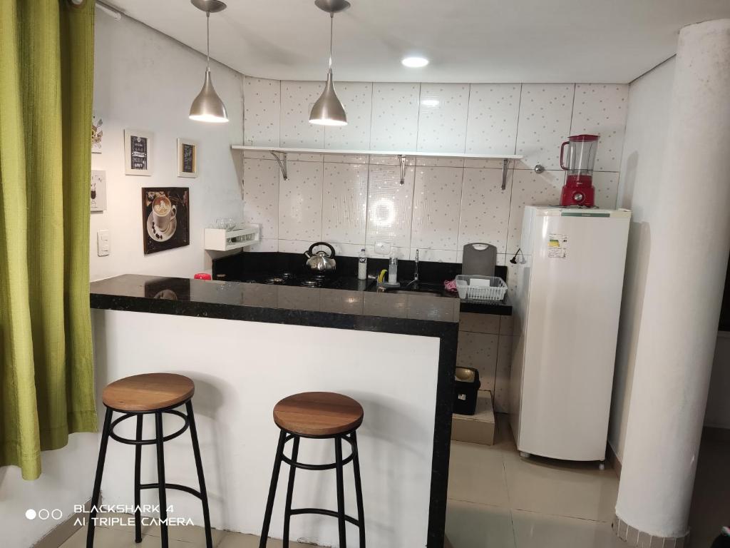 クリチバにあるApartamento Próximo ao Parque Bariguiのキッチン(バースツール2つ、冷蔵庫付)