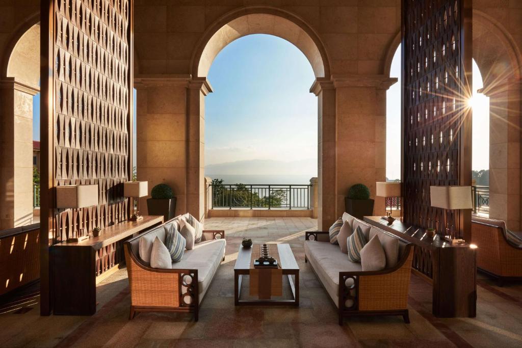 a lobby with couches and a view of the ocean at Hilton Yuxi Fuxian Lake in Chengjiang