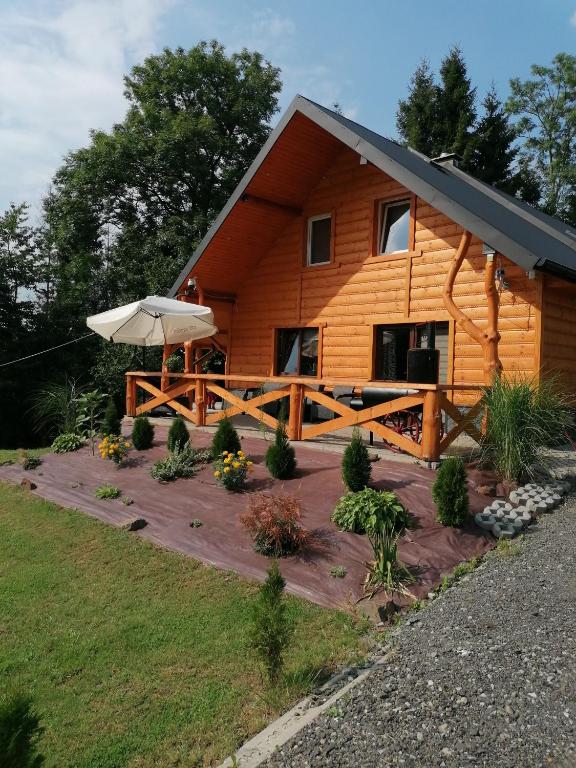a log cabin with an umbrella in front of it at Agroturystykadomkistawisko in Solina