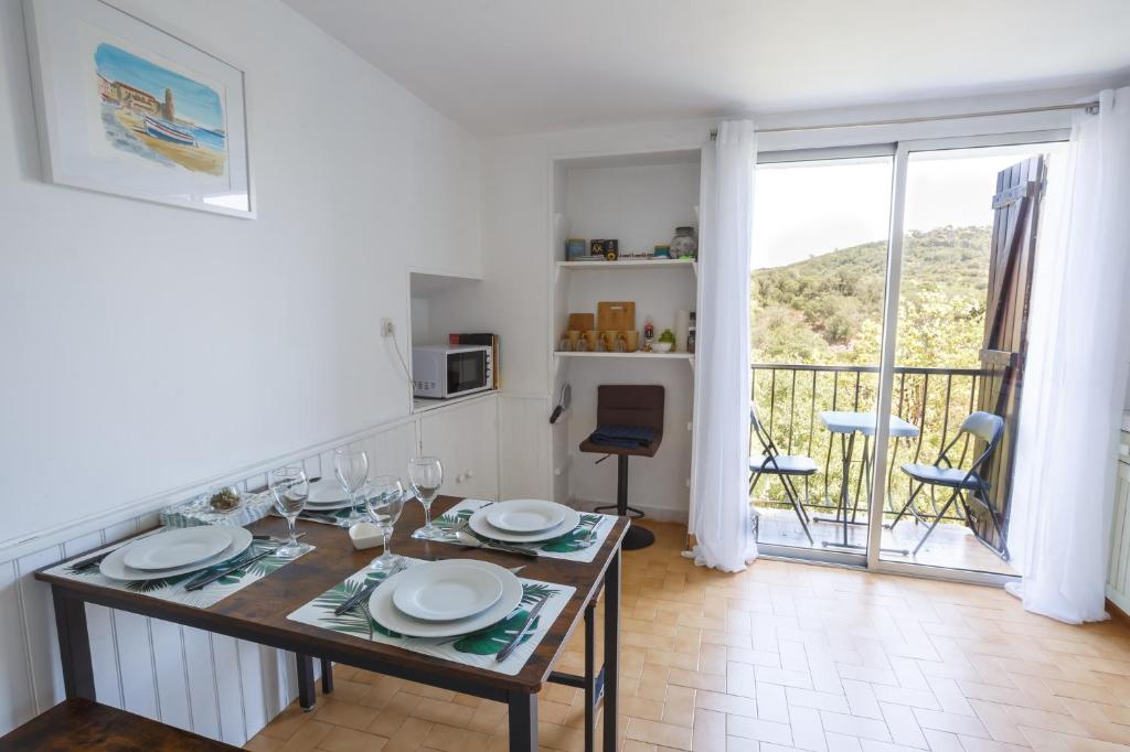 a dining room with a table and a balcony at Cosy Gîte in Gabian with Beautiful River and Vineyard Views in Gabian