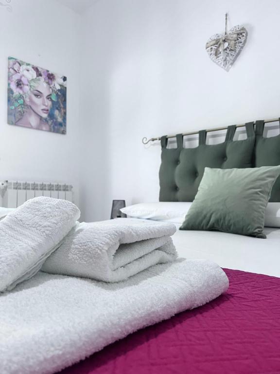 białe łóżko z stertą ręczników w obiekcie Appartamento il sole 2 piano w mieście Realmonte