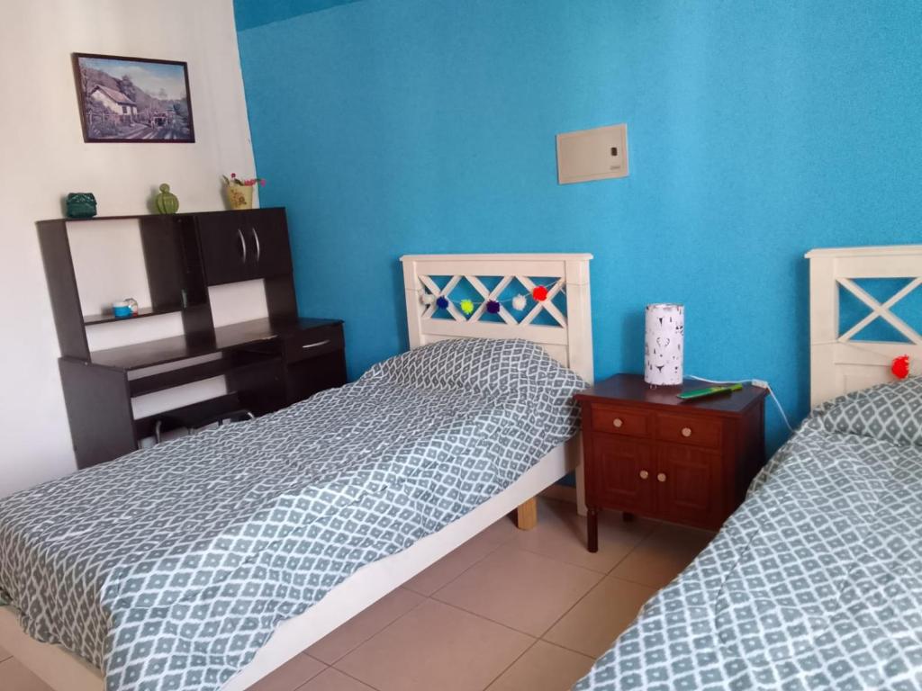two twin beds in a room with blue walls at Duplex Dorrego- Guaymallén in Guaymallen