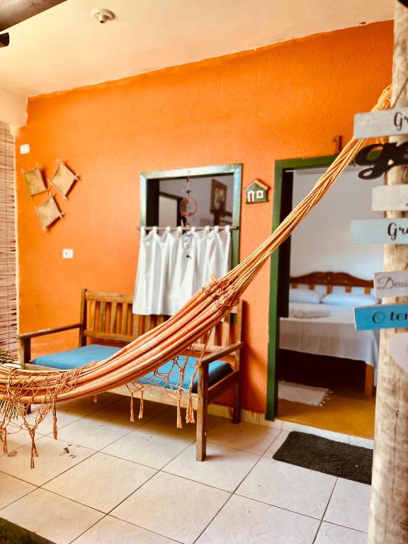 a hammock in a room with a bedroom at Pousada Clara Caraíva in Caraíva