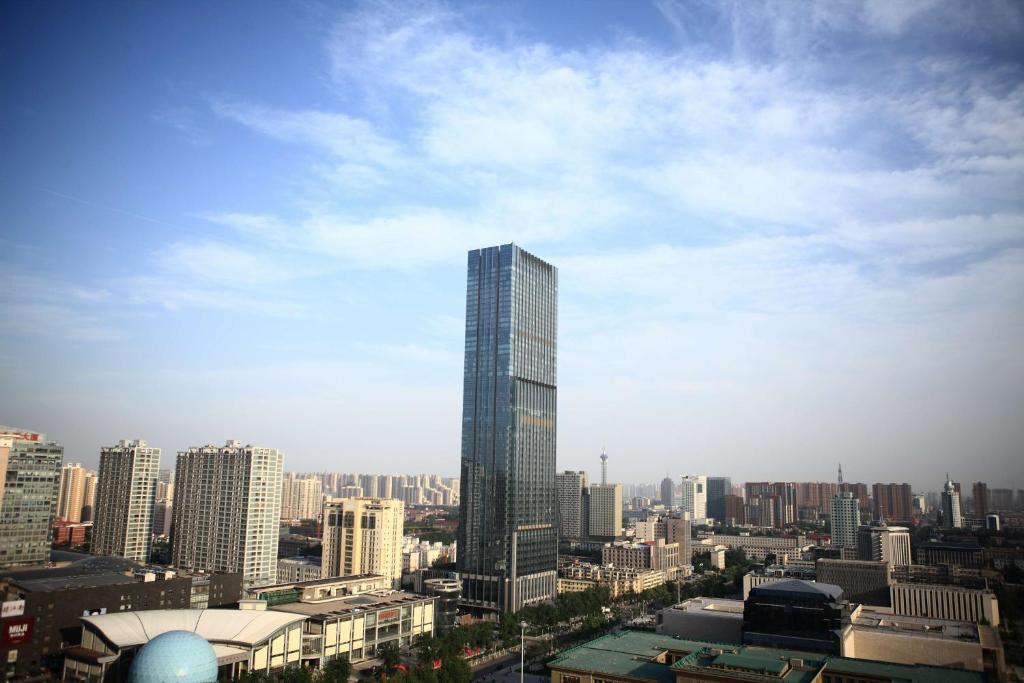 uma vista para uma cidade com um arranha-céus alto em Hilton Shijiazhuang em Shijiazhuang