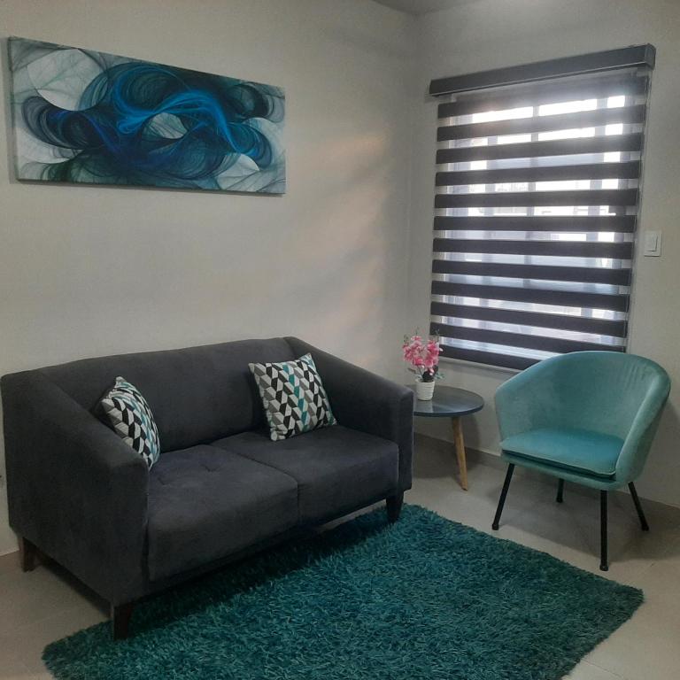 a living room with a couch and a blue chair at Hospedaje en Salamanca Residencial in Hermosillo