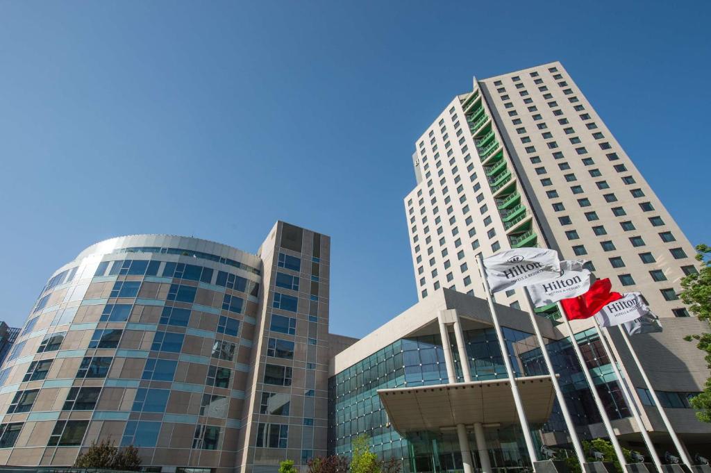 two tall buildings with street signs in front of them at Hilton Beijing in Beijing