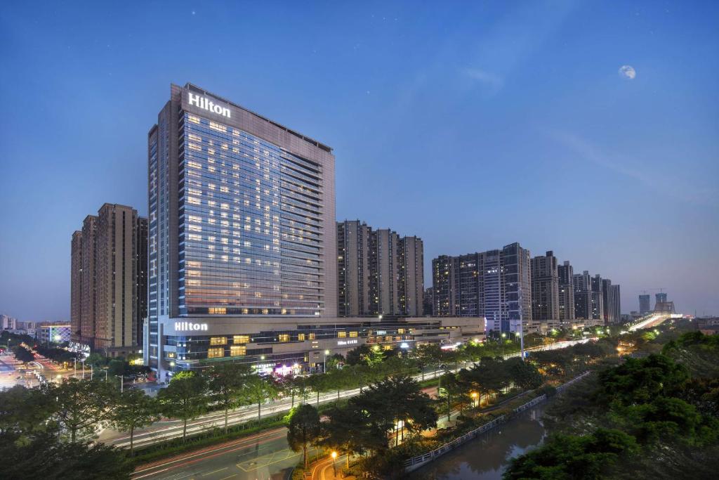 een hoog gebouw in een stad 's nachts bij Hilton Foshan in Foshan