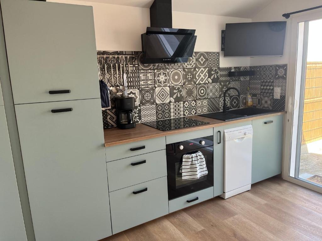 een keuken met een witte koelkast en een fornuis bij La landaise in Dax