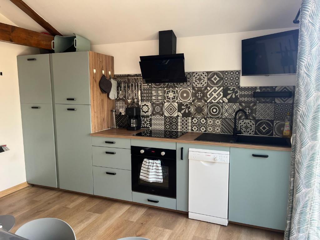 een keuken met een witte koelkast en een oven bij La landaise in Dax