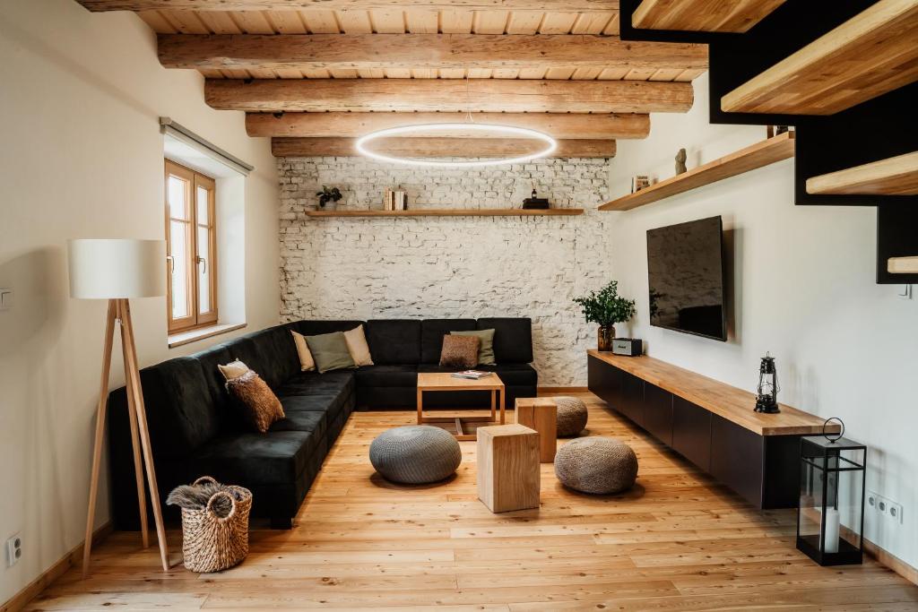 a living room with a black couch and a brick wall at Nebesky 81 in Kunčice pod Ondřejníkem