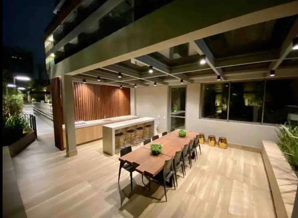duże patio z drewnianym stołem i krzesłami w obiekcie Studio Comfort ao lado do Metrô Moema w São Paulo