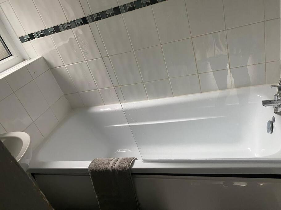 a bathroom with a white tub and a sink at Stonebridge Grove in Bramley