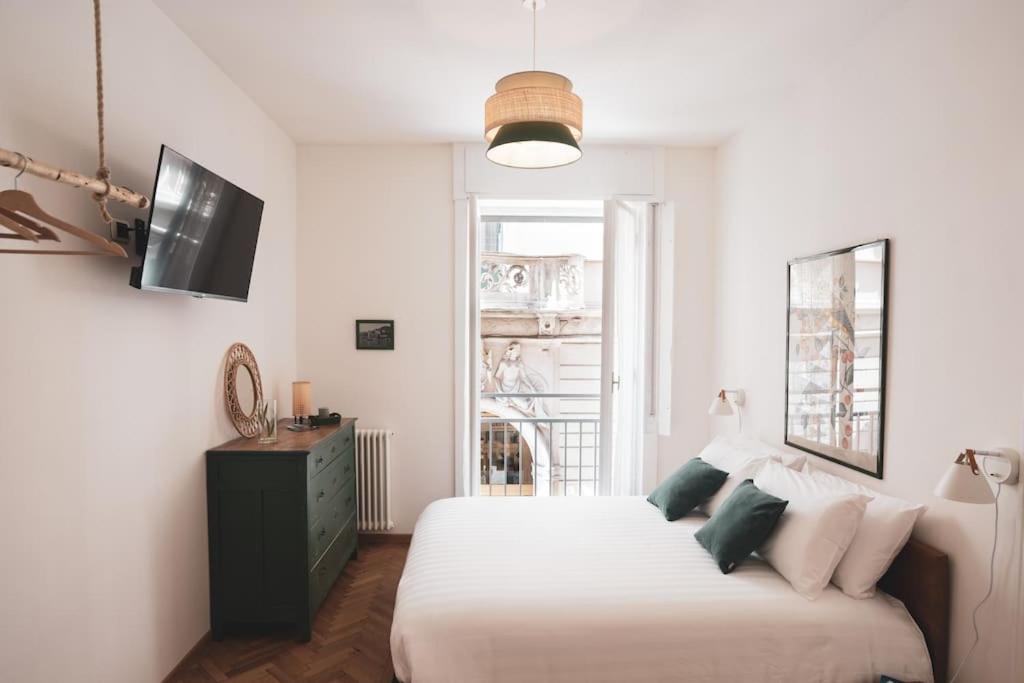 ein weißes Schlafzimmer mit einem Bett und einem TV in der Unterkunft Insidewonderfulcomo in Como